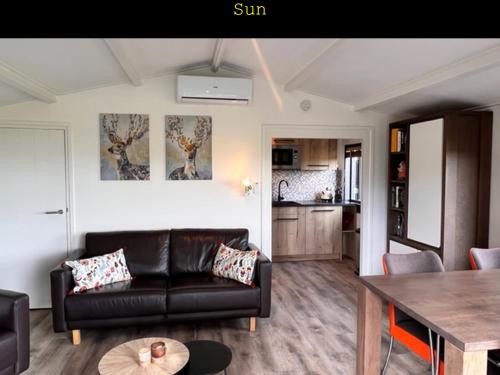 a living room with a couch and a table at Inn To the beach in Ouddorp