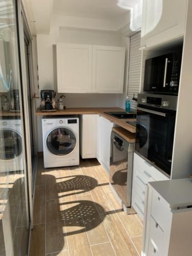 a kitchen with a washing machine and a washer at appart spa et mer in Bormes-les-Mimosas