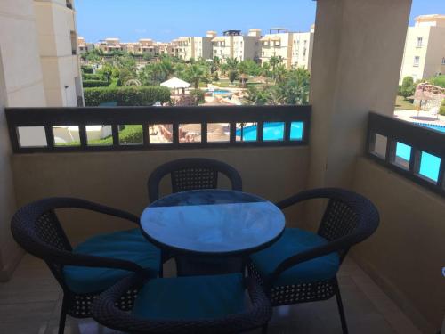 a table and chairs on a balcony with a view at شاليه قرية مرسيليا بيتش 3 مارسيليا عائلات فقط - Marseilia Beach 3 chalet Families Only in Dawwār Muḩammad Abū Shanab