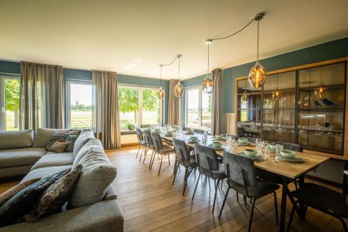 a living room with a long table and chairs at Blauwe Hoeve Luxe, ruimte, privacy en rust in Retranchement