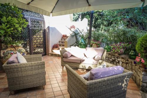 a patio with two wicker chairs and an umbrella at IL Tetto Di Guardia in Guardia Sanframondi