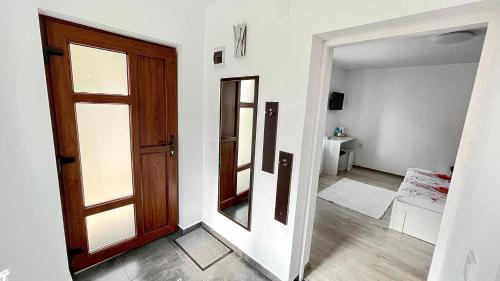een hal met een houten deur en een spiegel bij Apartament linistit / Cozy apartment in Câmpulung Moldovenesc