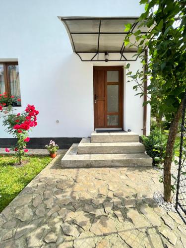 een huis met een stenen loopbrug naar een deur bij Apartament linistit / Cozy apartment in Câmpulung Moldovenesc