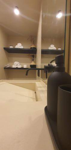 a bathroom with a mirror and a shelf with towels at Ammos ikia in Ouranoupoli