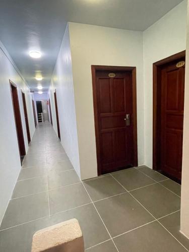 a hallway with two doors and a tile floor at Caye Caulker Beach Hotel in Caye Caulker