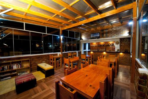 a restaurant with wooden tables and chairs and windows at El Jacal Classic in Huaraz
