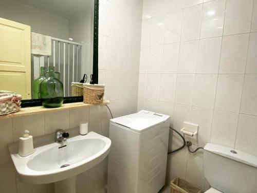 a white bathroom with a sink and a toilet at APARTAMENTO CON ENCANTO EN RESIDENCIAL CON PISCINA in Cala en Porter