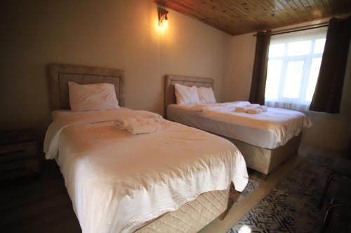 Kanyon park otel ve restaurant في ديميرجي: غرفة نوم بسريرين ونافذة