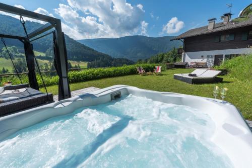 a jacuzzi tub in a backyard with a view at Villa Vintila with Whirlpool & Sauna in Vandoies