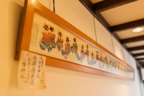 a picture hanging on a wall with writing on it at Ryokan Asunaro in Takayama