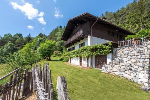 a house with a stone wall and a fence at Villa Vintila with Whirlpool & Sauna in Vandoies