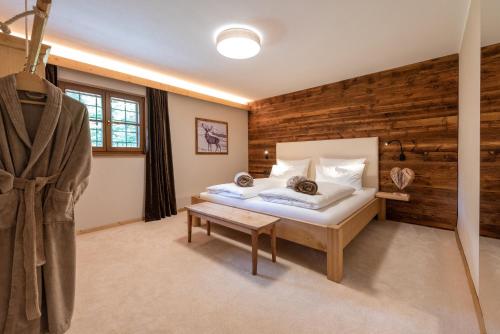 ein Schlafzimmer mit einem Bett und einer Holzwand in der Unterkunft Villa Vintila with Whirlpool & Sauna in Vintl