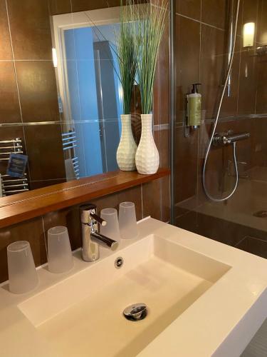 a bathroom sink with two vases and a mirror at Hotel De L'Océan in Biarritz