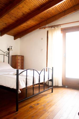 a bedroom with a bed and a large window at Agrampeli in Limenaria