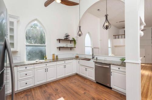 a kitchen with white cabinets and an arched window at The Sanctuary:Downtown Staunton in Staunton