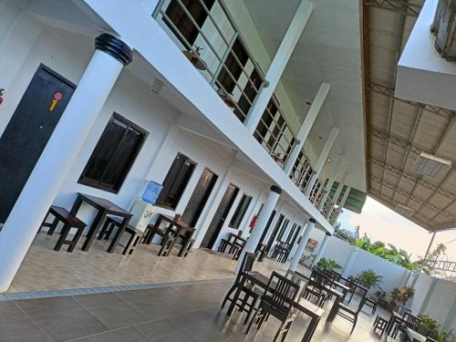 a group of chairs and tables in a building at RedDoorz at Buena's Pension Palawan in Puerto Princesa City