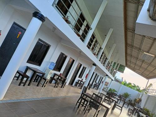 a group of chairs and tables in a building at RedDoorz Buena's Pension in Puerto Princesa City