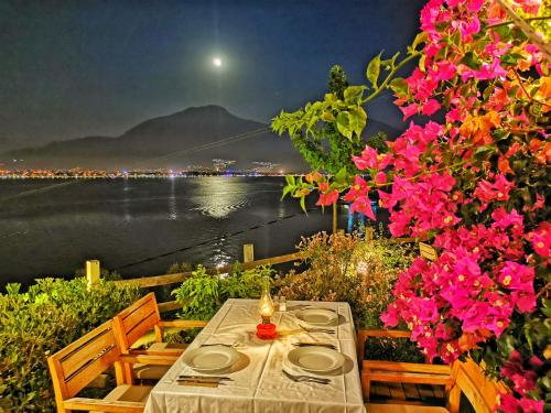 a table and chairs with a view of the water at Ece Hotel Sovalye Island in Fethiye