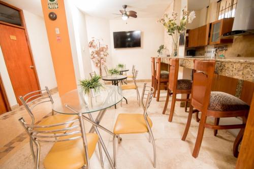 une salle à manger avec une table et des chaises en verre dans l'établissement Hotel La Coruña, à Piura