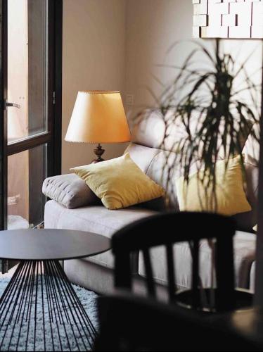 a living room with a couch and a lamp at Ático Guara&Pirineos in Huesca