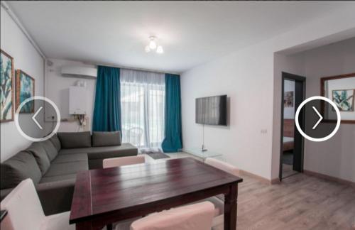 een woonkamer met een bank en een tafel bij Apartament Giulia by Sea View Luxury Residence in Mamaia Nord – Năvodari