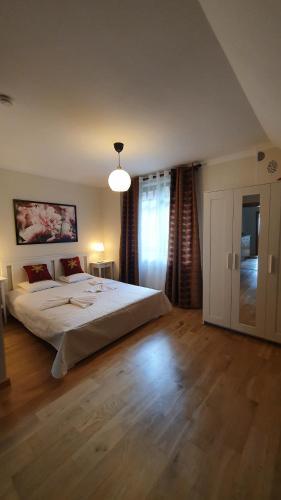 a bedroom with a large white bed and a lamp at Vāgnera parks in Tukums