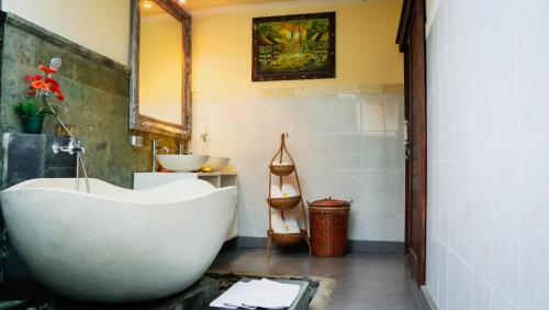 a bathroom with a white tub and a sink at Villa JJ and Spa Ubud in Ubud