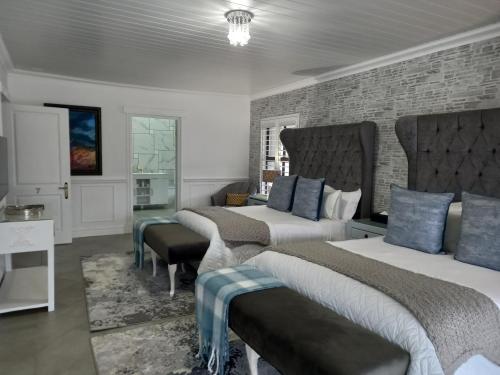 a bedroom with three beds and a brick wall at Linda se Dop in Nieuwoudtville