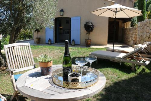 a table with a bottle of wine and glasses on it at Loup Castel Boutique Hotel B&B in Le Bar-sur-Loup