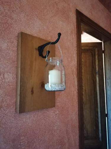 a candle in a glass jar hanging on a wall at Agriturismo Monte Gusciani in Massa Marittima