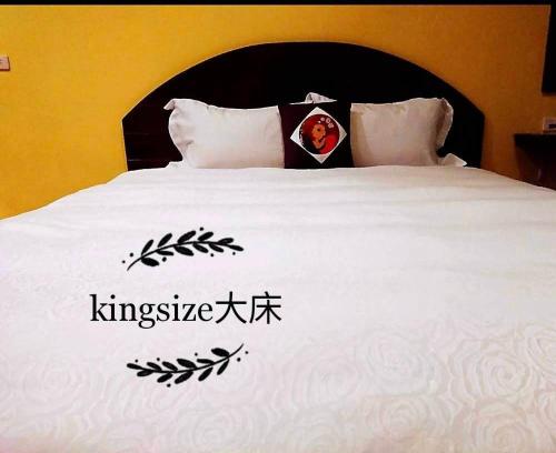 a king size bed with an asian writing on it at Mamamia Homestay in Hengchun