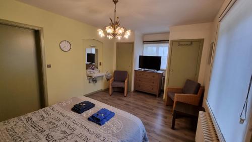 Un dormitorio con una cama con dos toallas azules encima. en B&B Villa Fernadine, en De Haan