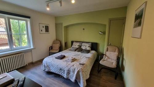 sypialnia z łóżkiem i 2 krzesłami w obiekcie B&B Villa Fernadine w mieście De Haan