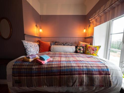 sypialnia z dużym łóżkiem z kolorowymi poduszkami w obiekcie Cosy Cottage with Spa, Catering, Nature Reserve Walks, Large Garden, Free Parking - Self Checkin w mieście Scunthorpe