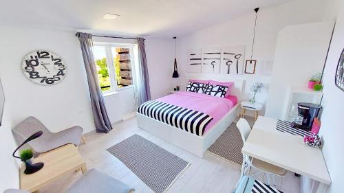 1 dormitorio con cama, escritorio y ventana en Le Petit 2 en Cilipi