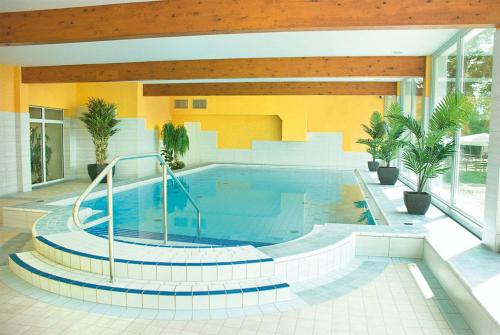 a large swimming pool in a building with a pool at Morada Hotel Isetal in Gifhorn