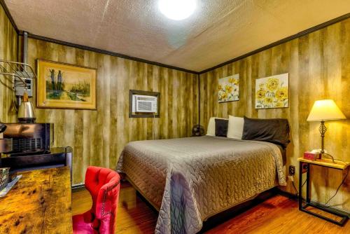 a bedroom with a bed and a red chair at Panther Creek Cabins in Cherokee