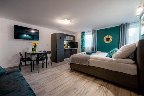 a bedroom with a bed and a table with chairs at Eromeni Apartments in Biały Dunajec