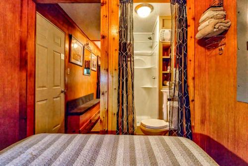 a bedroom with a bed and an open refrigerator at Panther Creek Cabins in Cherokee