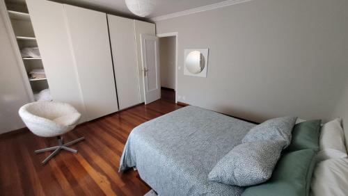 a bedroom with a bed and a chair in it at Casa del Patio in Cangas de Morrazo