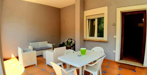 a dining room with a white table and white chairs at Villa Margot in Agropoli