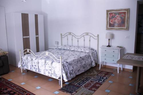 a bedroom with a white bed and a table at Villa Margot in Agropoli