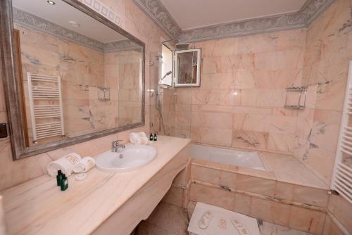 a bathroom with a sink and a tub and a mirror at THE WHITE PALACE Rabat in Rabat