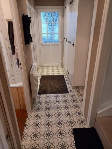 a hallway with a door and a tile floor at Maison chaleureuse et lumineuse à 400m de la plage in Veulettes-sur-Mer