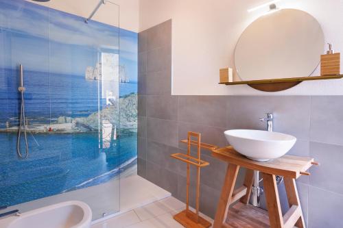 Un baño con lavabo y ducha de cristal. en Antonia Suite, en Cagliari