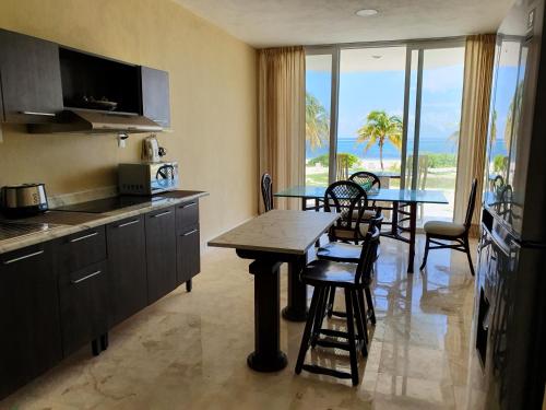 una cucina e una sala da pranzo con tavolo e sedie di Puerta del Mar Cozumel a Banco Playa