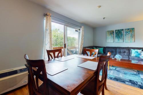 a dining room with a table and chairs and a couch at Lake Winnipesaukee Retreat in Gilford