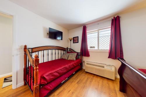 a bedroom with a red bed and a window at Lake Winnipesaukee Retreat in Gilford