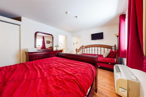 a bedroom with a bed with red sheets and a mirror at Lake Winnipesaukee Retreat in Gilford