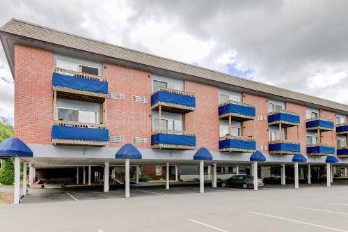 a large brick building with blue balconies and a parking lot at Lake Winnipesaukee Retreat in Gilford